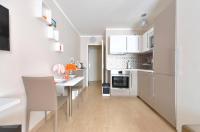 a kitchen with white cabinets and a table and chairs at Orange Studio Paris Disneyland in Serris