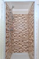a bathroom with a shower with wooden tiles at Orange Studio Paris Disneyland in Serris