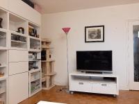 una sala de estar con TV en un centro de entretenimiento blanco en 2 bedrooms Apartment with parking Paris Neuilly, en Neuilly-sur-Seine
