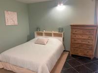 - une chambre avec un lit et une commode en bois dans l&#39;établissement Superbe studio privée au calme avec piscine et spa, à Sailly-lès-Lannoy