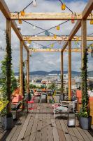 a wooden patio with tables and chairs on a roof at Zoku Vienna in Vienna