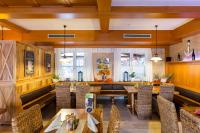 un restaurant avec des plafonds en bois, des tables et des chaises dans l'établissement Zum kleinen Italiener - Ristorante Pizzeria Pension, à Geinberg