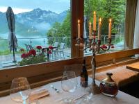 a table with wine glasses and candles and a window at Chalet Morel 1586 Hotel & Spa in Limone Piemonte
