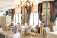 een restaurant met tafels en stoelen en een kroonluchter bij Cocos The Club Solto in Alacati