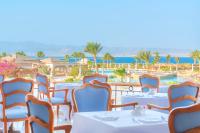 Un restaurante con mesas y sillas y vista al mar. en Kempinski Hotel Soma Bay, en Hurghada
