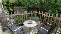 a patio with a table and two chairs and a fence at Het Lichthuis in Zandvoort