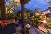 un patio al aire libre con mesas y sombrillas por la noche en Samanvaya - Adults Only, en Sidemen