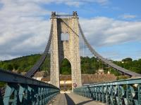 a suspension bridge in a city with a blue sky at Chambres d&#39;hôtes &amp; jacuzzi - A l&#39;ombre des amandiers in Saint-Martin-dʼArdèche