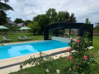 a swimming pool with a gazebo next to a yard at Château l&#39;Hubertière, classé du tourisme 4 étoiles in Bouresse