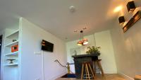 a living room with a staircase and a table and stool at Het Lichthuis in Zandvoort