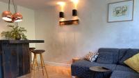 a living room with a blue couch and a table at Het Lichthuis in Zandvoort