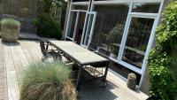 a wooden deck with a table and chairs on it at Het Lichthuis in Zandvoort