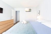 ein weißes Schlafzimmer mit einem großen Bett und einem TV in der Unterkunft Modern apartment 2 bedrooms quiet terrace in a palm beach area, 30 meters from seaside in Cannes