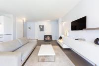 ein weißes Wohnzimmer mit einem Sofa und einem TV in der Unterkunft Modern apartment 2 bedrooms quiet terrace in a palm beach area, 30 meters from seaside in Cannes