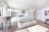 ein Wohnzimmer mit einem Sofa und einer Küche in der Unterkunft Modern apartment 2 bedrooms quiet terrace in a palm beach area, 30 meters from seaside in Cannes