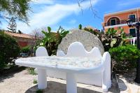 a white bench sitting in front of a building at Alisaxni Studios in Argassi