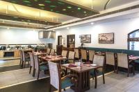 een restaurant met houten tafels en stoelen en een bar bij Club Mahindra Cherai Beach in Cherai Beach