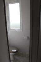 a bathroom with a toilet and a window at Les mobiles Homes de la Palmyre in Les Mathes