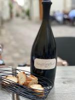 a bottle of wine sitting next to a basket of bread at Le Charles VII in Chinon