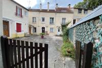 a fence in front of a building with houses at Studio de charme - calme, discret &amp; cosy - 3&#39; RER in Évry-les-Châteaux