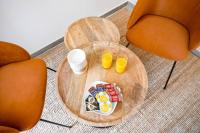 a table with two orange chairs and two glasses of orange juice at Studio de charme - calme, discret &amp; cosy - 3&#39; RER in Évry-les-Châteaux