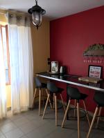 a kitchen with a table with chairs and a red wall at Saint Vincent in Bué