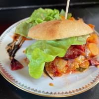 Un sándwich en un plato con una ensalada encima. en Au Presbytère de Saigneville, en Saigneville