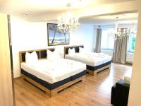 a bedroom with two beds and a chandelier at Anker Self-Check-In Hotel in Lindau