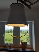 a lamp hanging over a table in front of a window at La Pause in Plombières