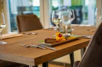 ein Holztisch mit einem Teller mit Essen und Weingläsern in der Unterkunft Altes Zollhaus in Rinteln