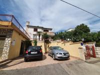 two cars parked in a parking lot in front of a house at Apartments Tortuga in Dramalj