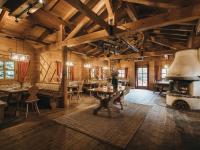 Una gran sala con techos y mesas de madera y una chimenea. en VAYA Achensee, en Achenkirch