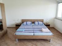 - une chambre avec un lit et 2 oreillers dans l&#39;établissement Apartments Delfini, à Sveti Filip i Jakov