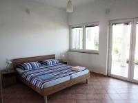 - une chambre avec un lit avec deux oreillers et deux fenêtres dans l&#39;établissement Apartments Delfini, à Sveti Filip i Jakov