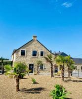 a building with palm trees in front of it at Domaine de kerbillec in Theix