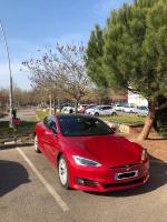 a red tesla car parked in a parking lot at Nota Bene in Montceau-les-Mines
