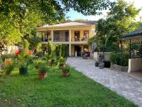 a house with potted plants in the yard at Nargiz&#39;s Guest House in Batumi