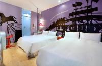 two beds in a room with purple walls at NL Concept Hotel in Kaohsiung