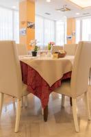 einen Esstisch mit 2 Stühlen und einer Tischdecke in der Unterkunft Hotel Nobel in Rimini