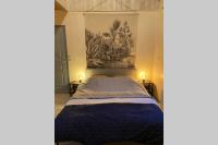 a bedroom with a blue bed with a painting on the wall at Ancien Moulin rénové à neuf pour 20 personnes sur les rives du Trieux in Plésidy