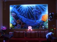 a teddy bear sitting on a couch in front of a giant screen at Hai Yang Feng Qing Homestay in Hualien City