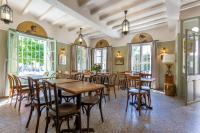 a dining room with tables and chairs and windows at Hôtel Le Relais de Poste Arles Centre Historique in Arles