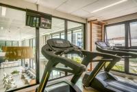 a gym with two exercise bikes in a room with windows at Porto Kaeté Hotel in Maceió