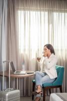 a woman sitting at a table drinking from a cup at Porto Kaeté Hotel in Maceió