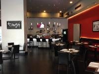 Un restaurante con mesas y sillas y un bar. en Hotel Principe, en Panamá