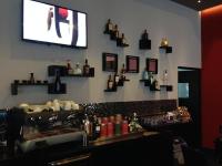 un bar con TV en una pared con botellas en Hotel Principe, en Panamá