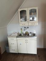 a kitchen with white cabinets and a sink at Babarczi Üdülőház in Kiskunmajsa