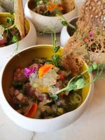 Un tazón de sopa con verduras y pan sobre una mesa. en Pavillon des Millésimes, Piscine & SPA, en Lussac