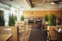 Un restaurante con mesas, sillas y plantas. en Hotel Buntrock, en Holzminden