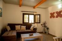 a living room with a couch and a table at flamingo colour valey house in Palekastron